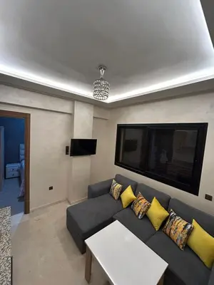 a living room with a couch and a table at Studio au centre ville de marrakech avec piscine in Marrakech