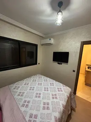 a bedroom with a bed and a television in it at Studio au centre ville de marrakech avec piscine in Marrakech
