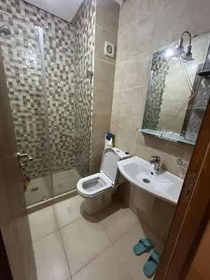 a bathroom with a toilet and a sink and a shower at Studio au centre ville de marrakech avec piscine in Marrakech