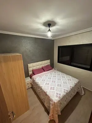 a bedroom with a bed and a flat screen tv at Studio au centre ville de marrakech avec piscine in Marrakech