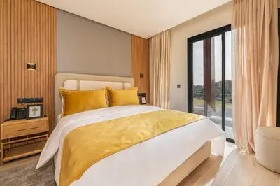 a bedroom with a large bed and a large window at Appart Hôtel Rambla in Marrakech