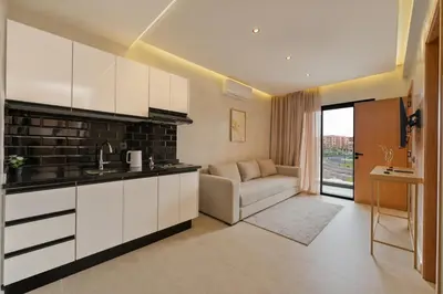 a kitchen with white cabinets and a couch in a room at Appart Hôtel Rambla in Marrakech