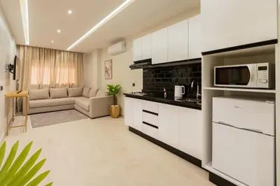 a kitchen and living room with a couch and a microwave at Appart Hôtel Rambla in Marrakech