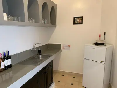 a kitchen with a sink and a white refrigerator at Riad Rosita 4 chambres in Marrakech