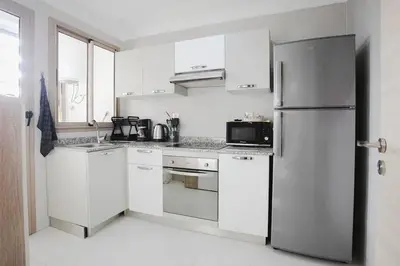 a kitchen with white cabinets and a stainless steel refrigerator at La Dolce Casa – Private Pool in Marrakech