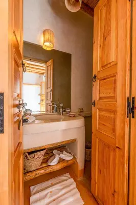 a bathroom with a tub and a sink and a mirror at Riad Mama in Marrakech