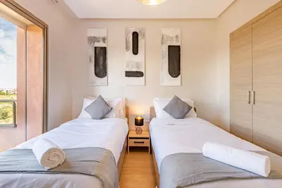 two beds sitting next to each other in a room at Perle Rare A Prestigia 2 Ch Avec Vue Incroyable in Marrakech
