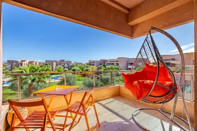 a hammock on a balcony with a table and chairs at Perle Rare A Prestigia 2 Ch Avec Vue Incroyable in Marrakech