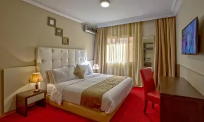 a hotel room with a large bed and a desk at Yaad City Hotel in Marrakech