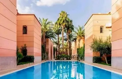 a swimming pool in the middle of a building at Riad yazuinaa in Marrakech