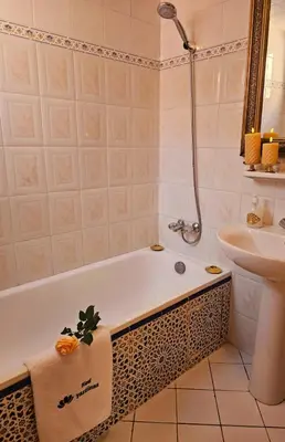 a bathroom with a bath tub and a sink at Riad yazuinaa in Marrakech