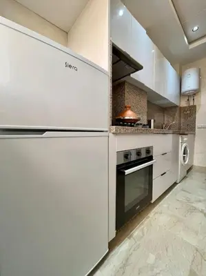 a white kitchen with a stove and a microwave at Yumo: The Cozy One in Marrakech