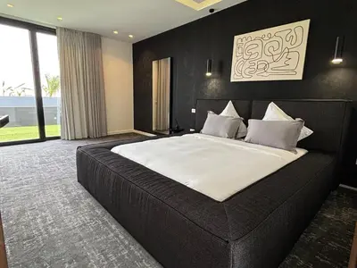 a bedroom with a large bed with a black wall at Palais Kahli in Marrakech