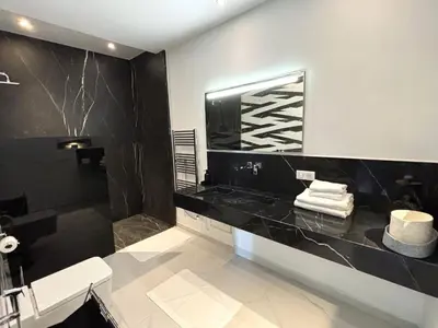 a bathroom with a black counter and a sink at Palais Kahli in Marrakech
