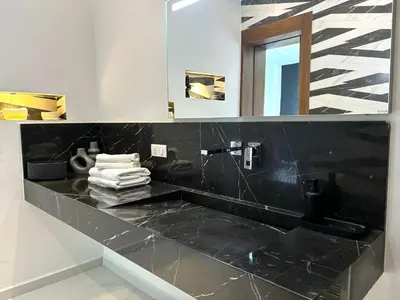 a bathroom with a black counter top and a mirror at Palais Kahli in Marrakech