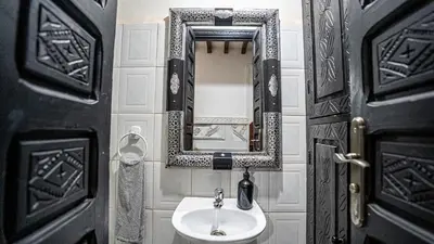 a bathroom with a sink and a mirror at Riad Lalla Aicha -Piscine, 3 suites climatisées & terrasse in Marrakech