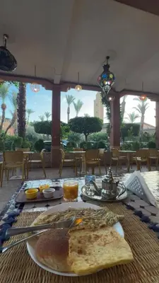 a table with a plate of food on it at Riad Lalla Aicha -Piscine, 3 suites climatisées & terrasse in Marrakech