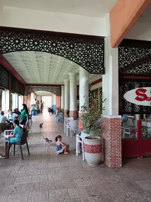 a child sitting on the ground in front of a restaurant at Riad Lalla Aicha -Piscine, 3 suites climatisées & terrasse in Marrakech