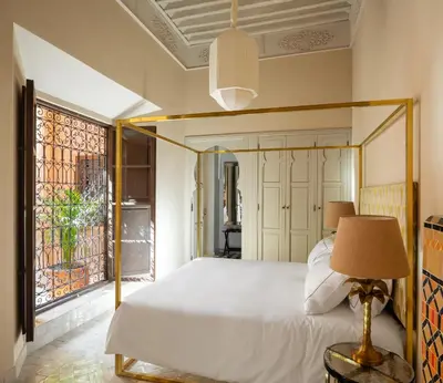 a bedroom with a bed and a large window at Riad Dar Al Dall - This Time Tomorrow in Marrakech in Marrakech