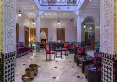 a lobby with chairs and tables in a building at Riad Des Nations in Marrakech