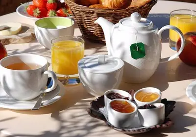 a table with cups of tea and a basket of fruit at Riad Des Nations in Marrakech
