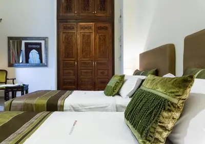 two beds in a hotel room with sidx sidx sidx at Riad Des Nations in Marrakech