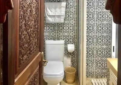 a bathroom with a white toilet in a room at Riad Des Nations in Marrakech