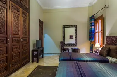 a bedroom with a bed and a tv and a mirror at Riad Des Nations in Marrakech