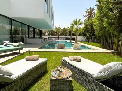 a backyard with a swimming pool and a house at Palais Thami in Marrakech