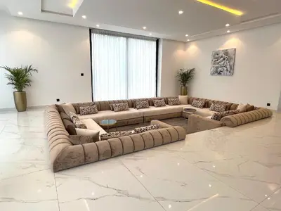 a large living room with long couches and tables at Palais Thami in Marrakech