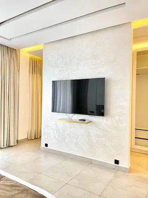 a living room with a tv on a wall at Palais Thami in Marrakech