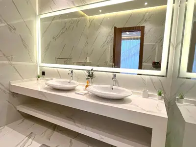 a bathroom with two sinks and a large mirror at Palais Thami in Marrakech