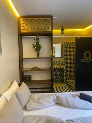 a bedroom with a white bed and a room with a door at RIAD KS & SPA in Marrakech