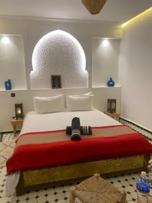 a bedroom with a large bed with a red blanket at RIAD KS & SPA in Marrakech