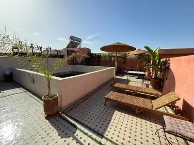 a patio with chairs and an umbrella on a building at RIAD KS & SPA in Marrakech