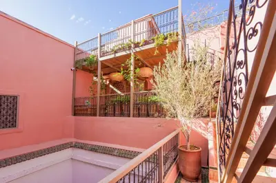 a staircase in a pink house with potted plants at Riad Kiwi - Private Historic Riad Jacuzzi & Hammam - Entire Home in Marrakech