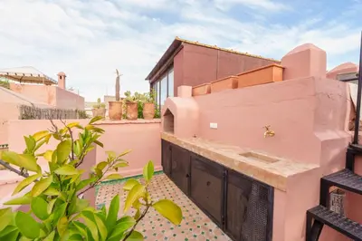 a balcony of a house with pink walls at Riad Kiwi - Private Historic Riad Jacuzzi & Hammam - Entire Home in Marrakech