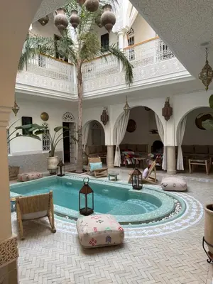 a swimming pool in a building with a palm tree at Riad Zayn & Spa in Marrakech