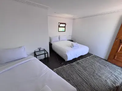 a bedroom with two beds and a window at Riad Dar Zarbia in Marrakech
