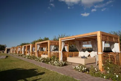 a row of wooden pavilions in a park at THE FARM LODGES & Private pool in Marrakech