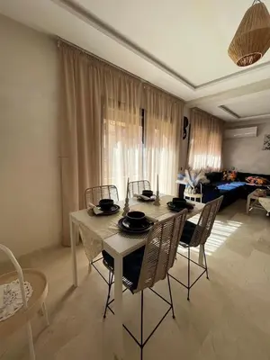 a dining table and chairs in a living room at Charming Appartment in Gueliz in Marrakech
