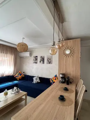 a living room with a blue couch and a table at Charming Appartment in Gueliz in Marrakech