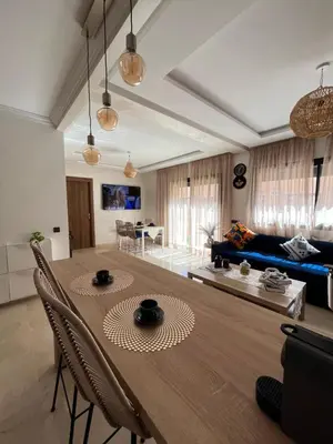 a living room with a table and a blue couch at Charming Appartment in Gueliz in Marrakech