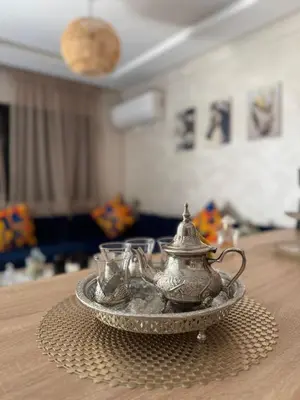 a silver tea pot and two glasses on a table at Charming Appartment in Gueliz in Marrakech