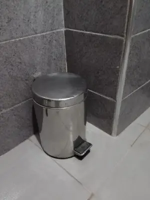 a trash can with a black lid in a bathroom at Airport Home in Marrakech