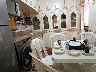 a kitchen with a table and chairs and a washing machine at Airport Home in Marrakech