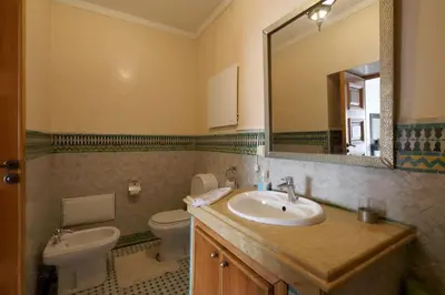 a bathroom with a sink and a toilet and a mirror at Typical large central appt in Gueliz with nice view in Marrakech