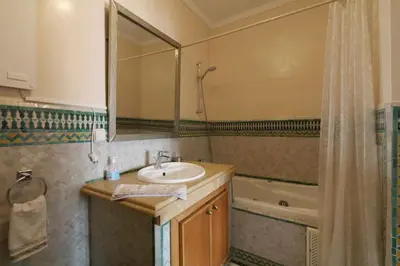 a bathroom with a sink and a mirror and a tub at Typical large central appt in Gueliz with nice view in Marrakech