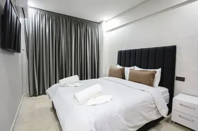 a bedroom with a large white bed with a black headboard at Golden Skyline – Marrakech in Marrakech