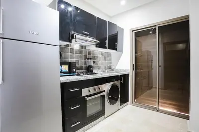 a kitchen with a refrigerator and a washer and dryer at Golden Skyline – Marrakech in Marrakech